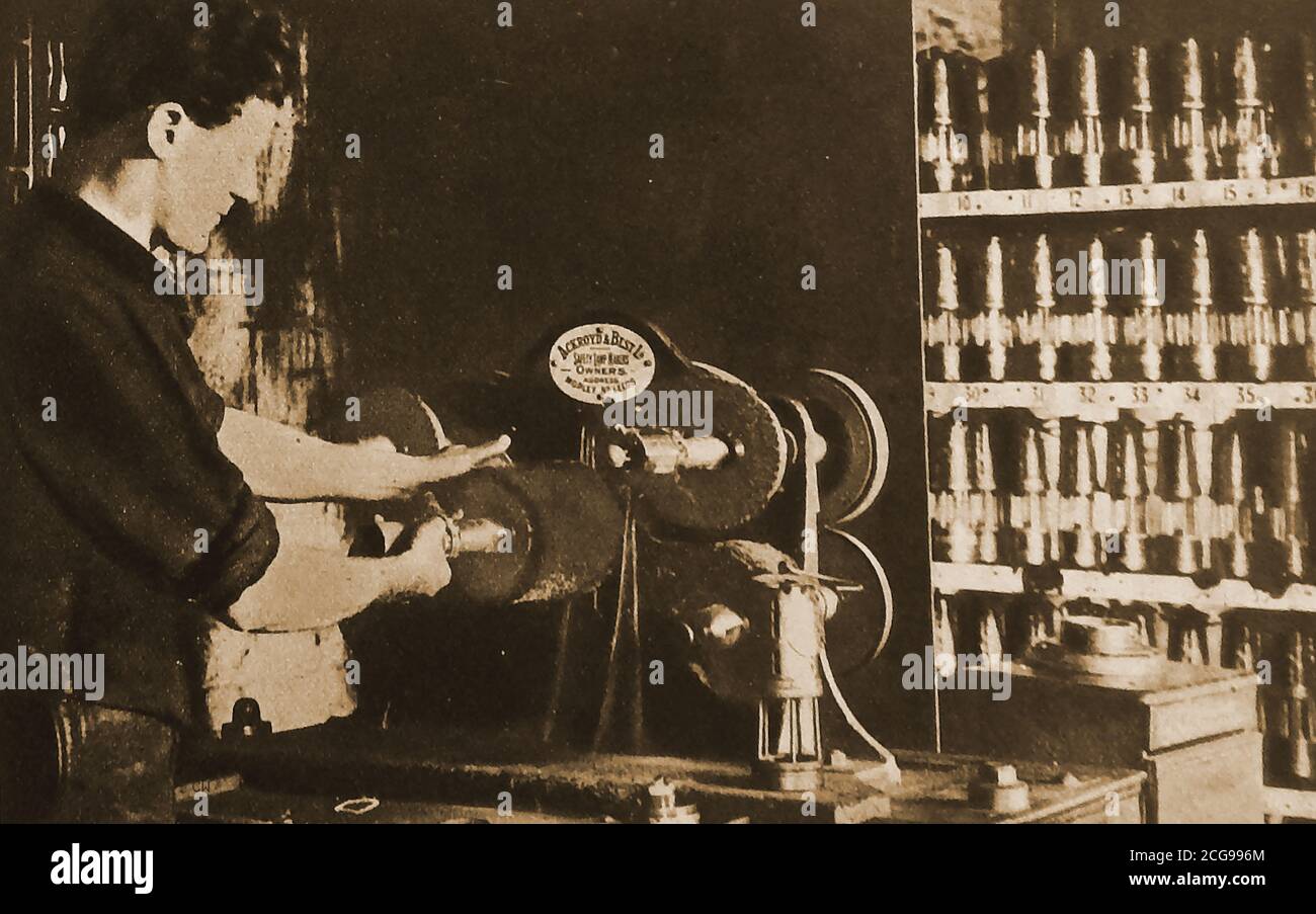 1921 Foto eines Handwerkers, dessen einzige Aufgabe darin bestand, Bergarbeiterlampen für den Einsatz in der britischen Kohleindustrie zu fertigen, zu renovieren oder zu reparieren. Er verwendet eine Maschine mit der Kennzeichnung Ackroyd & Best Ltd, Sicherheitslampen Hersteller von Morley, Leeds, Yorkshire. Sie wurden manchmal als Hailwood und Ackroyd Ltd. Bezeichnet.Oddly, sie prägten auch Münzen und Token, darunter einige für die East African Currency Board Stockfoto