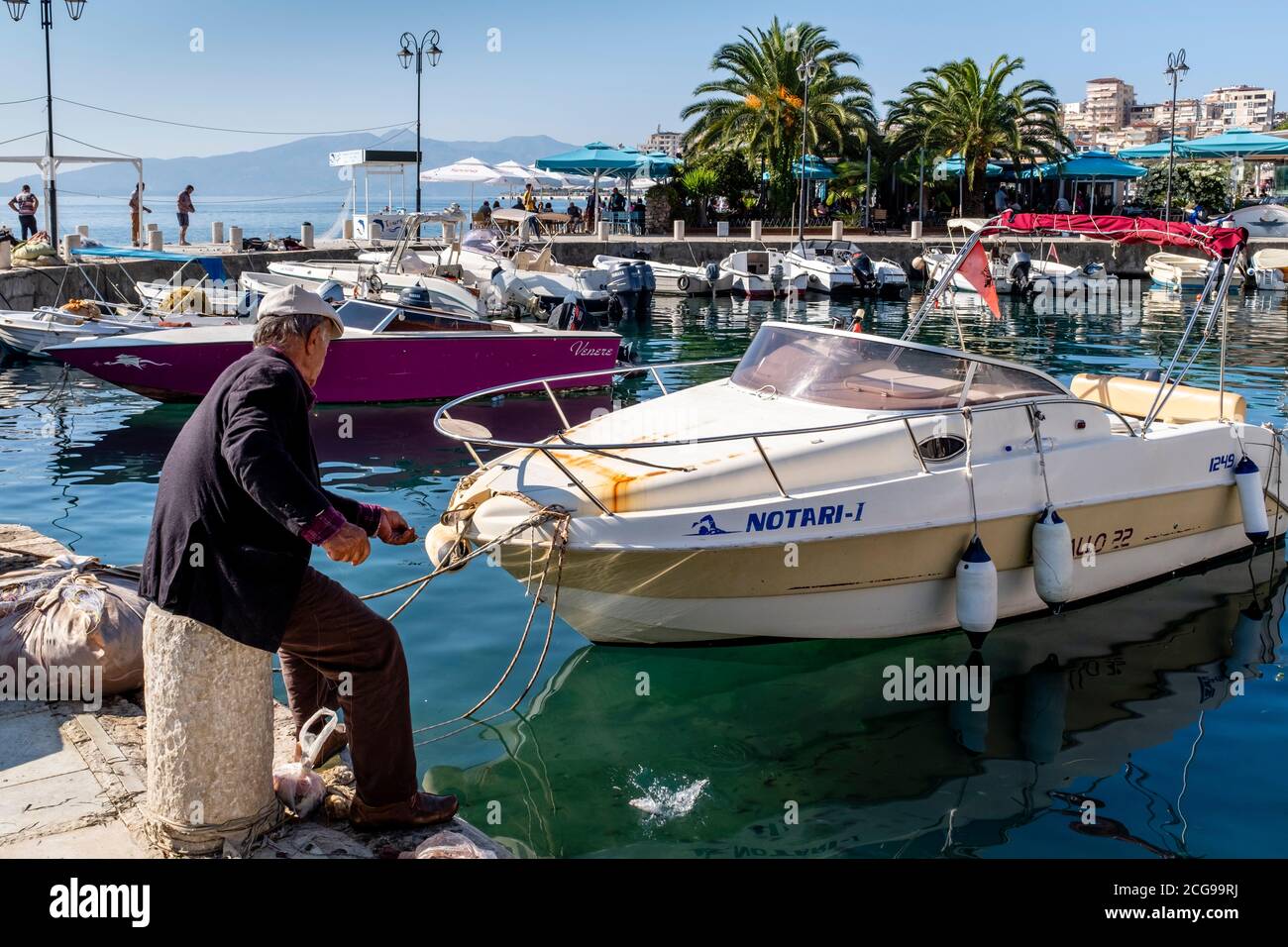 Ein Einheimischer, der im Hafen, Saranda, Albanien angeln kann. Stockfoto