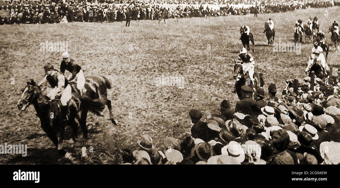 Der 1920 englische Derby-Sieger Spion Kop nähert sich dem Siegerposten. ---- das 1920 Epsom Derby war ein Pferderennen, das am 2. Juni 1920 in Epsom Downs stattfand. Es war der 141. Lauf des Derby und wurde von Giles Loder's Spion Kop gewonnen. Der Sieger wurde von dem amerikanischen Jockey Frank O'Neill (in 2 Minuten 34.8 Sekunden) geritten. Das Pferd wurde von Peter Gilpin trainiert. Das Preisgeld betrug £5850. 2. Platz ging an Archaic, geritten von George Bellhouse, 3. War Orpheus geritten von Felix Leach, Junior und trainiert von Felix Leach Senior. Stockfoto