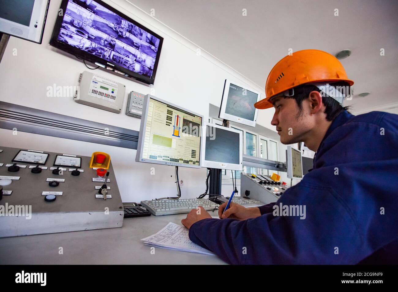 Titanmetallurgie-Anlage. Der junge Arbeiter steuert die Verarbeitung von schmelzendem Titan mit Vakuum-Lichtbogen furnace.computers und Lampenanzeigen. Stockfoto