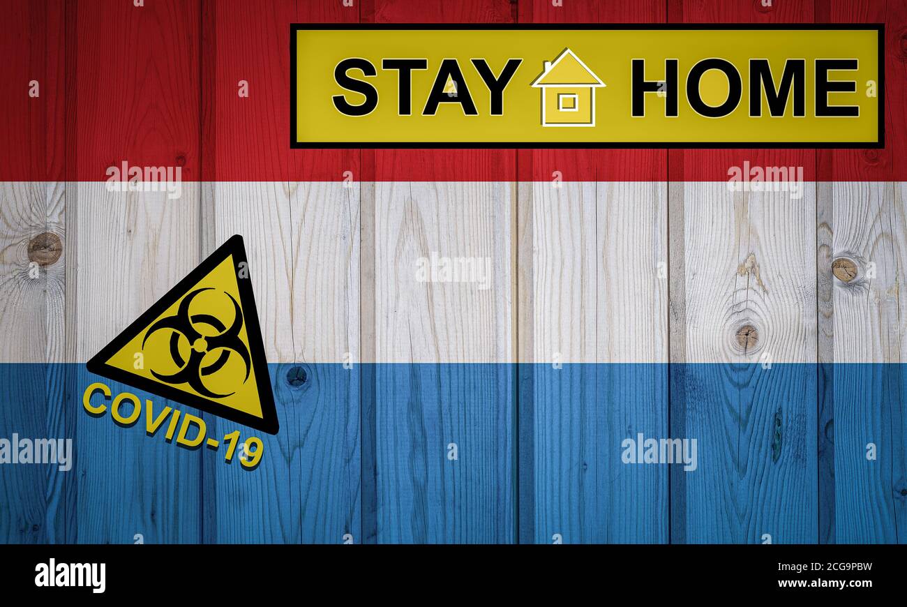 Flagge der Luxemburger in Originalproportionen. Quarantäne und Isolation - zu Hause bleiben. Flagge mit Biohazard-Symbol und Inschrift COVID-19. Stockfoto