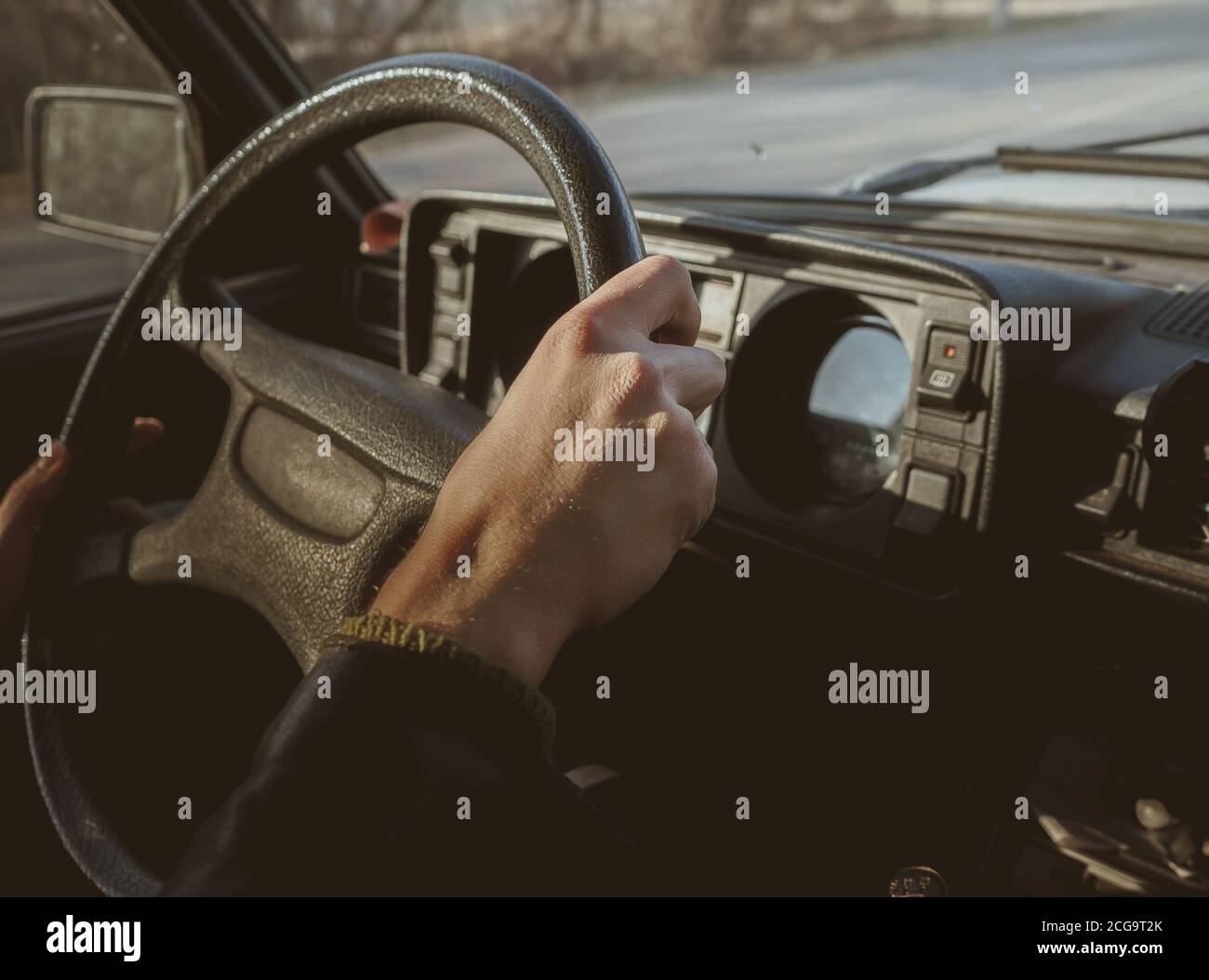 Eine Männerhand am Lenkrad eines Klassikers Auto Stockfoto