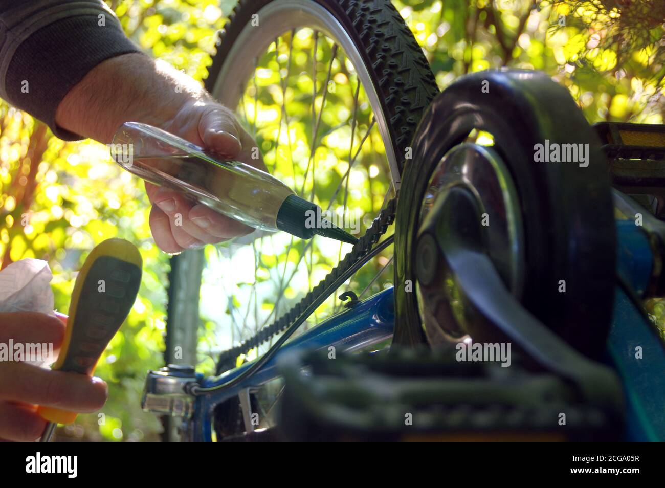 Die Pflege des Fahrrads im Freien. Reparatur der Kette auf einem Zahnrad auf einem Fahrrad. Stockfoto