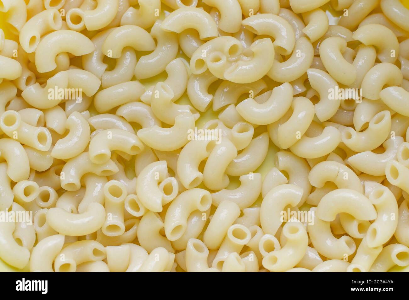 Gekochte Pastahörner aus der Nähe, gelber Hintergrund Stockfoto
