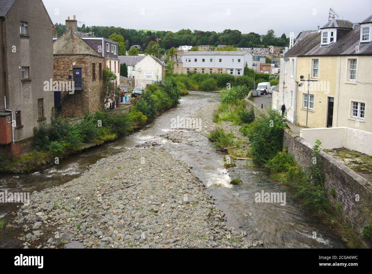 Slitrig Wasser fließt zwischen Häusern in Hawick kurz vor dem Anschluss an den Fluss Teviot. Stockfoto