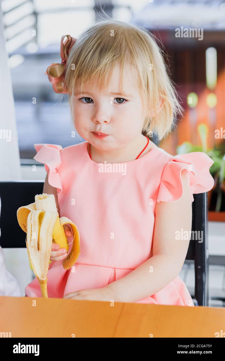 Ein Mädchen isst eine Banane Stockfoto