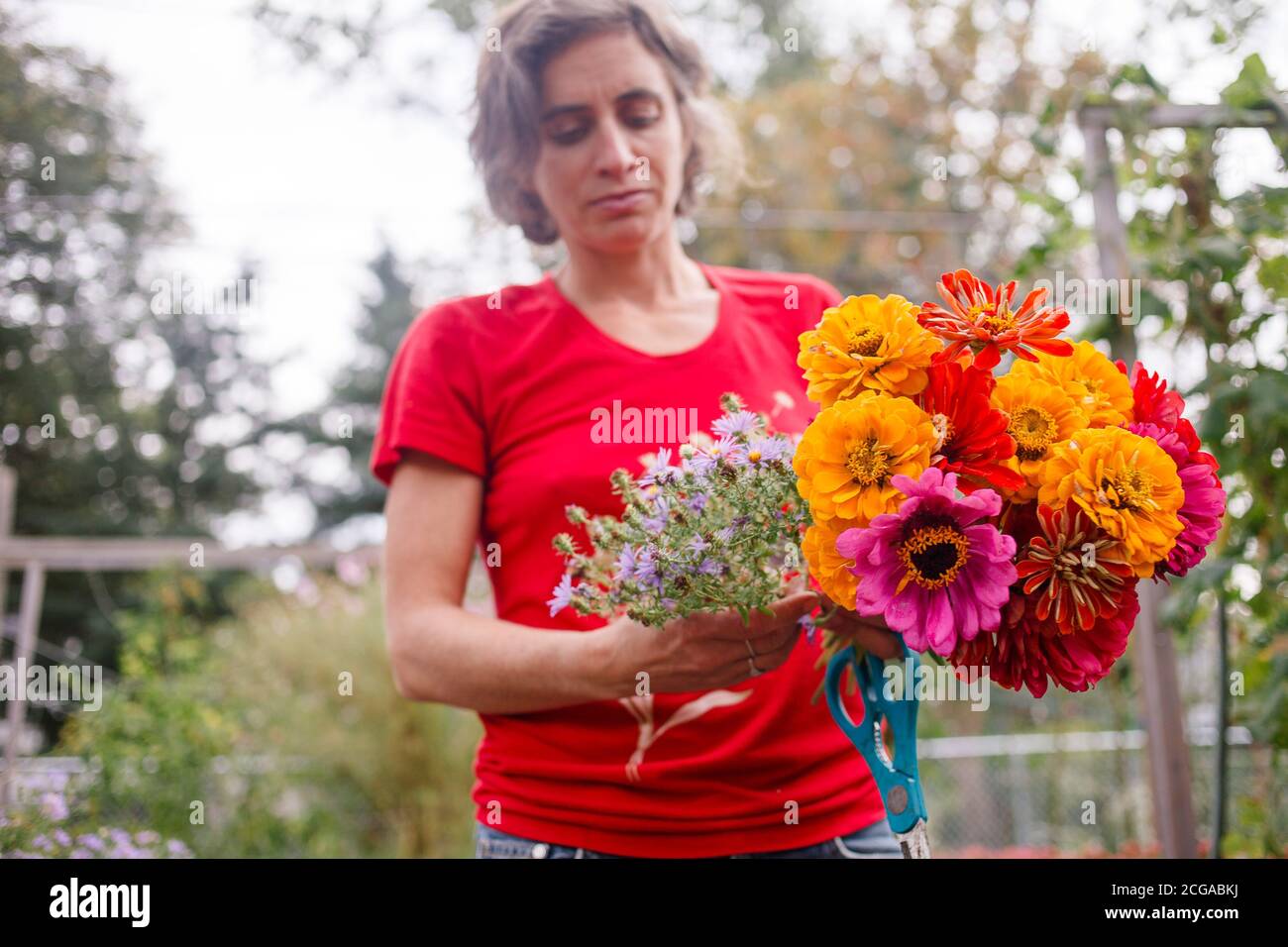 Eine Gärtnerin hält einen hellen Strauß Wildblumen aus Stockfoto