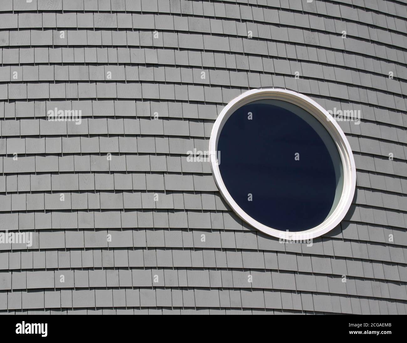 Kreisförmiges Fenster auf einem geschwungenen Gebäude. Stockfoto