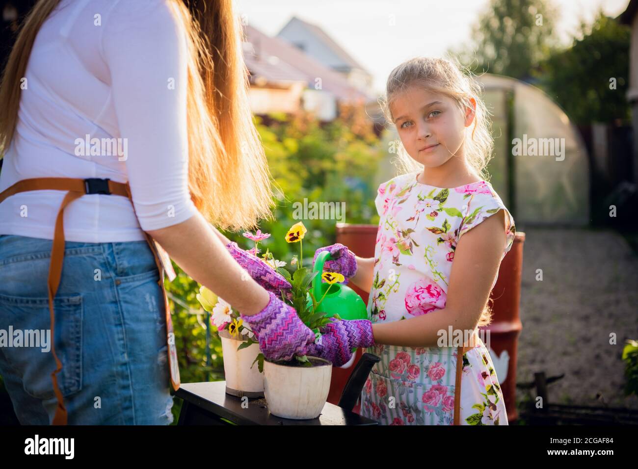 Gartenarbeit - Glückliche Mutter mit Tochter im Garten arbeiten Stockfoto