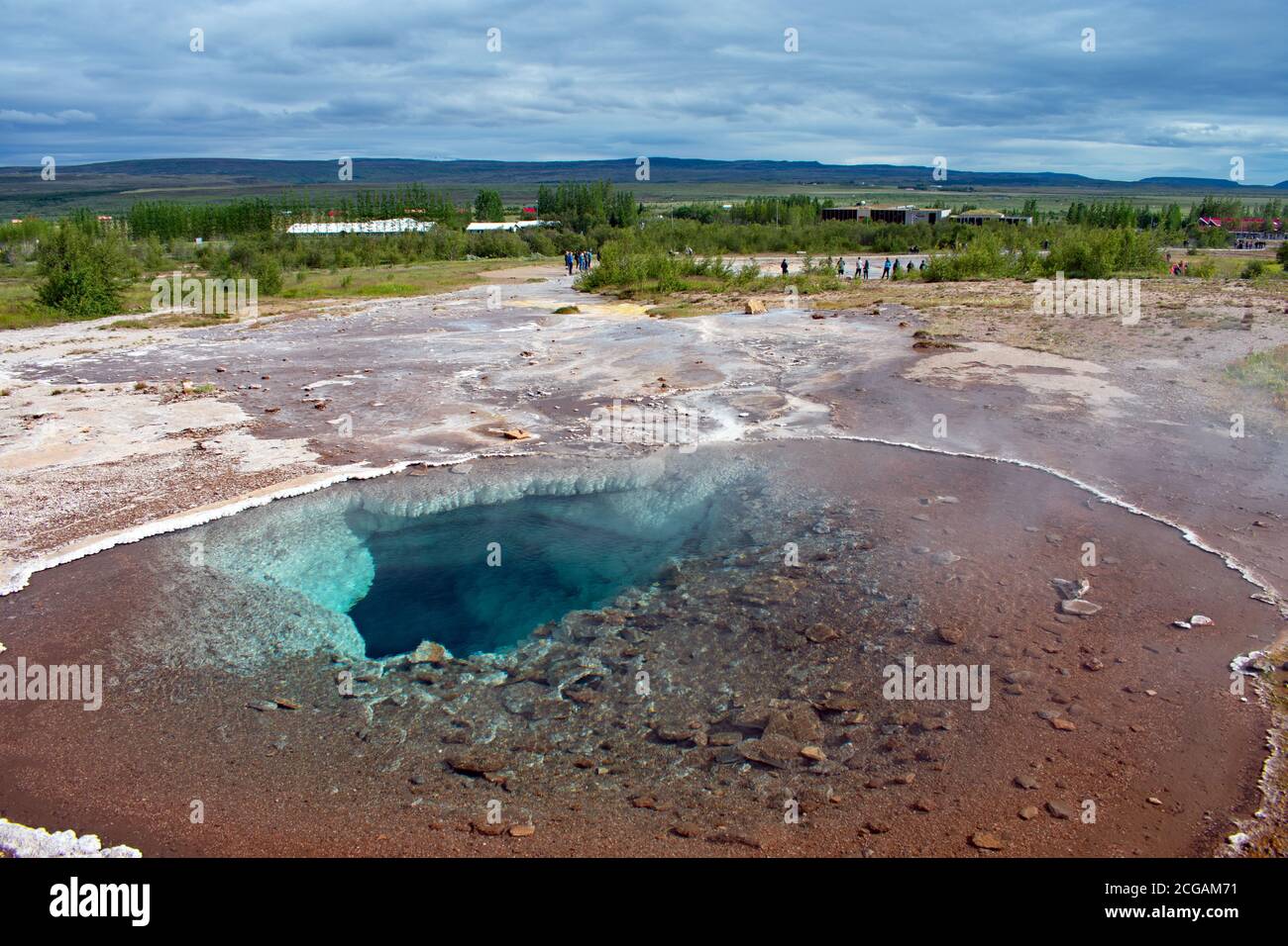 Das südliche Auge der Blesi Hot Springs mit dem Geysir Geothermal Gebiet ausbreitend. Touristen warten auf die nächste Eruption in Strokkur. Stockfoto