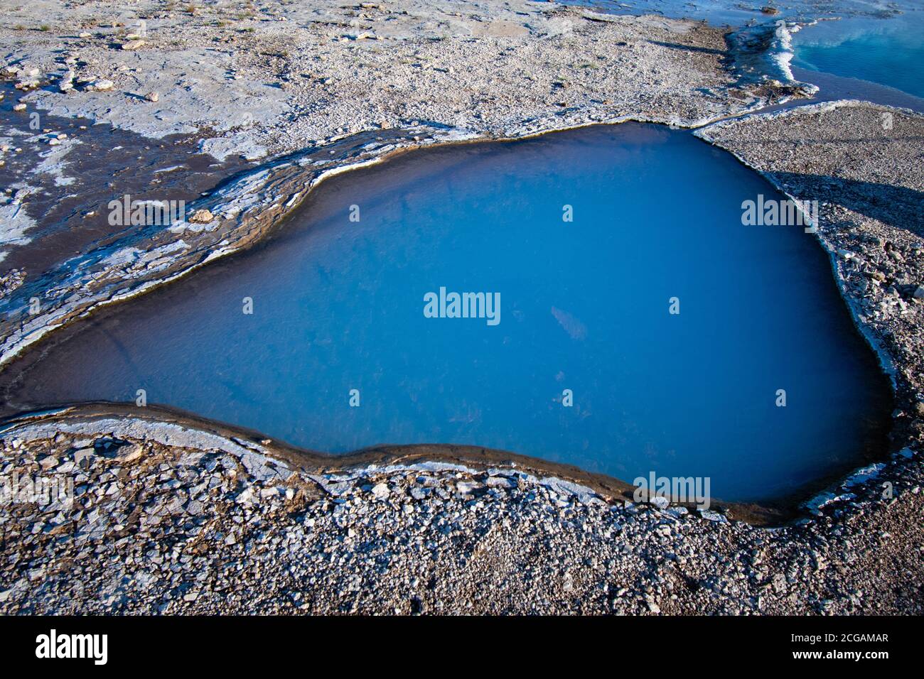 Nahaufnahme der tiefen milchigen blauen Farbe und des umgebenden Felsens des nördlichen Auges der Blesi Hot Spring. Geysir Geothermal Area, Golden Circle, Island. Stockfoto