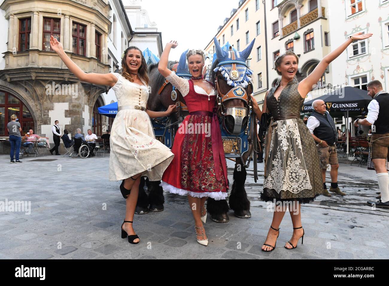 München, Deutschland. September 2020. Der Wiesnplaymate 2019 Stella Stegmann (l-r) der Wiesnplaymate 2020, Natascha Hofmann und der Wiesnplaymate 2017, Patrizia Dinkel, zeigen sich bei der Präsentation des Playboy Wiesn-Playmate 2020 vor dem Hofbräuhaus am Platzl mit einem Pferd und Wagen aus der Hofbräu Brauerei. Das Playboy-Magazin präsentierte in diesem Jahr einen Wiesn-Playmate, obwohl das Oktoberfest aufgrund der Corona-Pandemie überhaupt nicht stattfindet. Quelle: Felix Hörhager/dpa/Alamy Live News Stockfoto