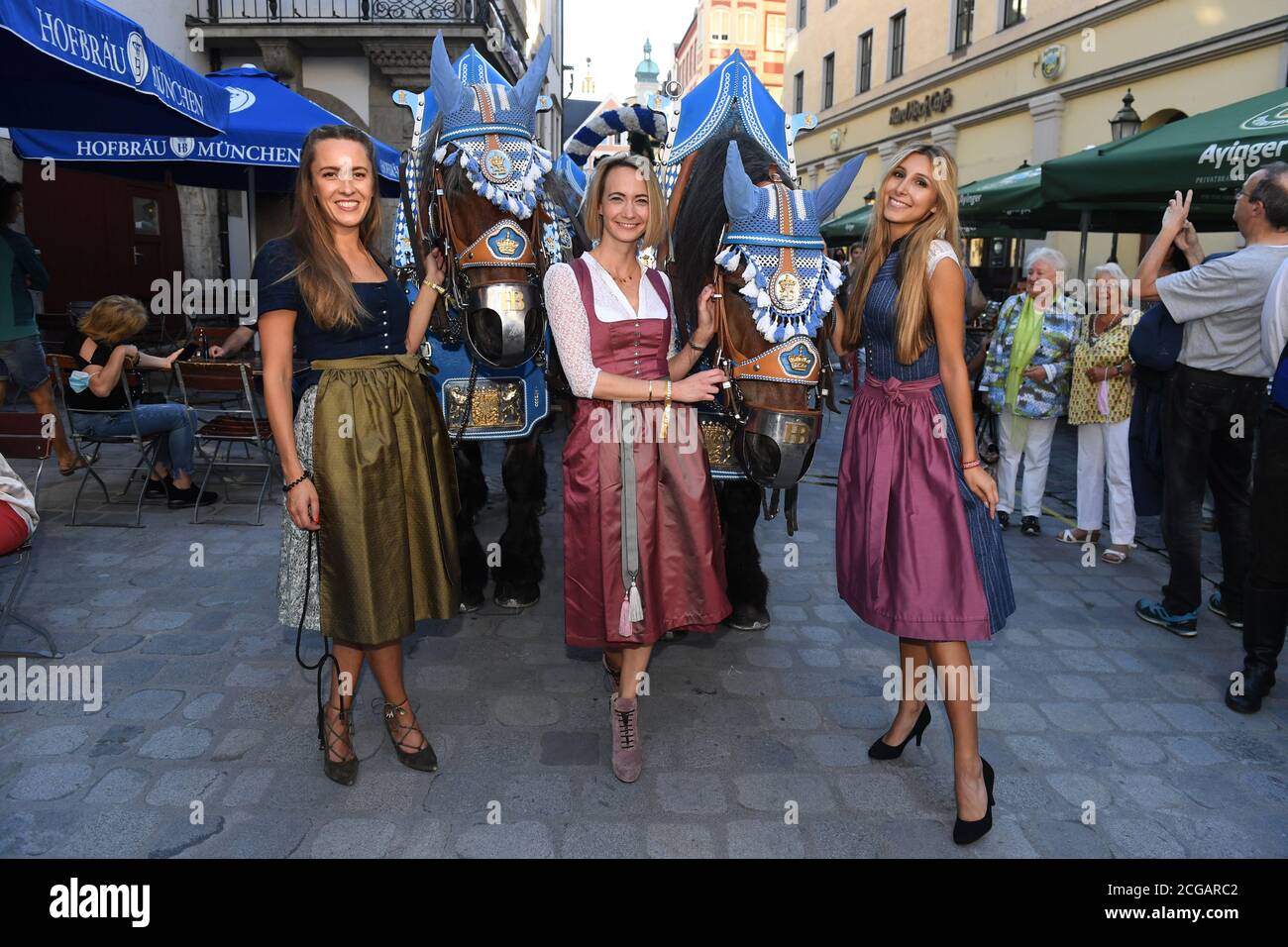 München, Deutschland. September 2020. Die Modelle Verena Angermaier, (l-r) Eileen Popelaty und Miriam Franz zeigen sich mit einer Pferdekutsche der Hofbräu-Brauerei bei der Präsentation des Playboy Wiesn-Playmate 2020 vor dem Hofbräuhaus am Platzl. Das Playboy-Magazin präsentierte in diesem Jahr einen Wiesn-Playmate, obwohl das Oktoberfest aufgrund der Corona-Pandemie überhaupt nicht stattfindet. Quelle: Felix Hörhager/dpa/Alamy Live News Stockfoto