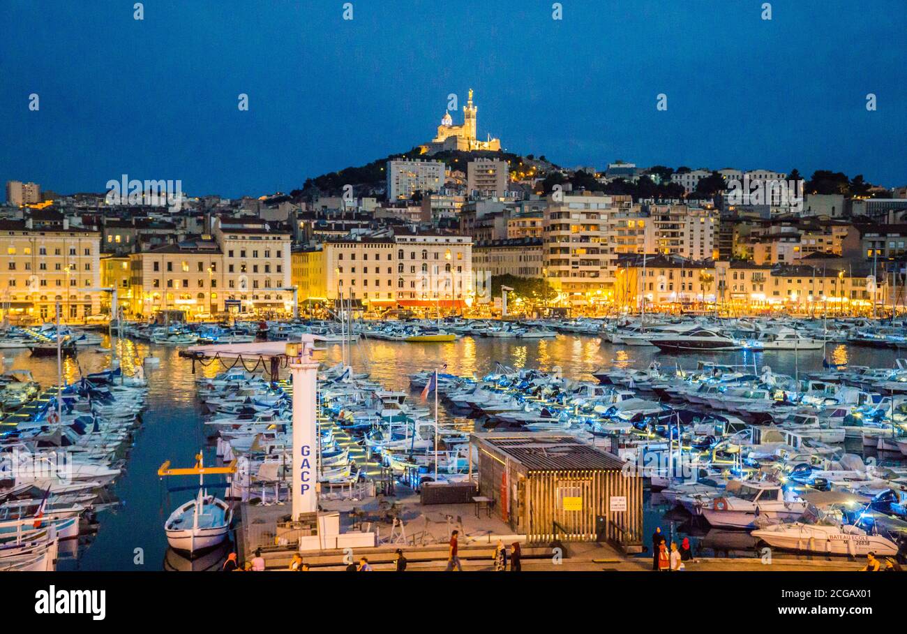 Abendansicht von Vieux Port, dem Alten Hafen von Marseille mit Basilique Notre-Dame de la Garde im Hintergrund auf dem höchsten natürlichen Punkt in Marseille Stockfoto