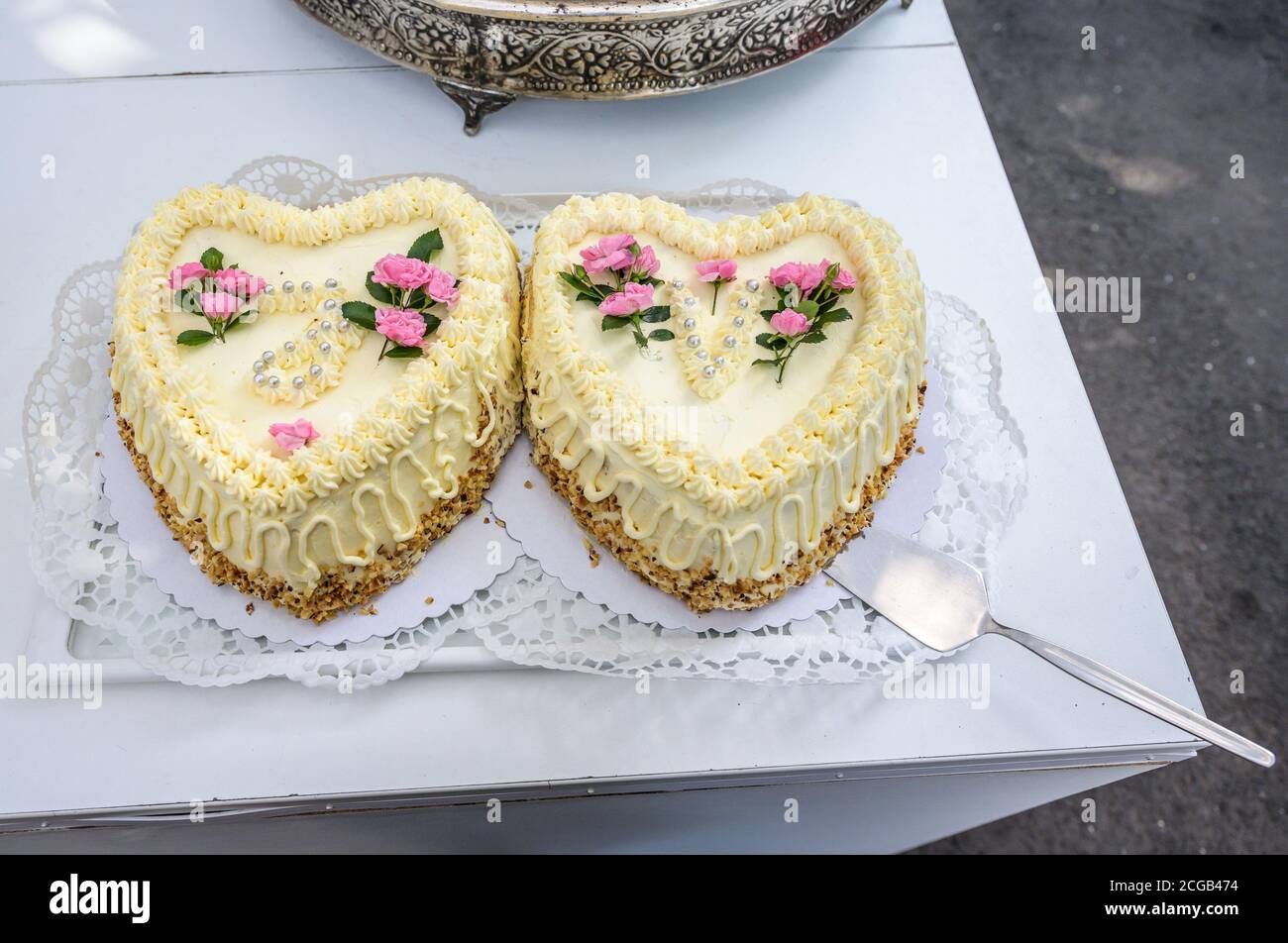 Romantische Hochzeit zwei Kuchen in Herzform, Rosenstrauß auf weißem  Tischhintergrund. Draufsicht Stockfotografie - Alamy