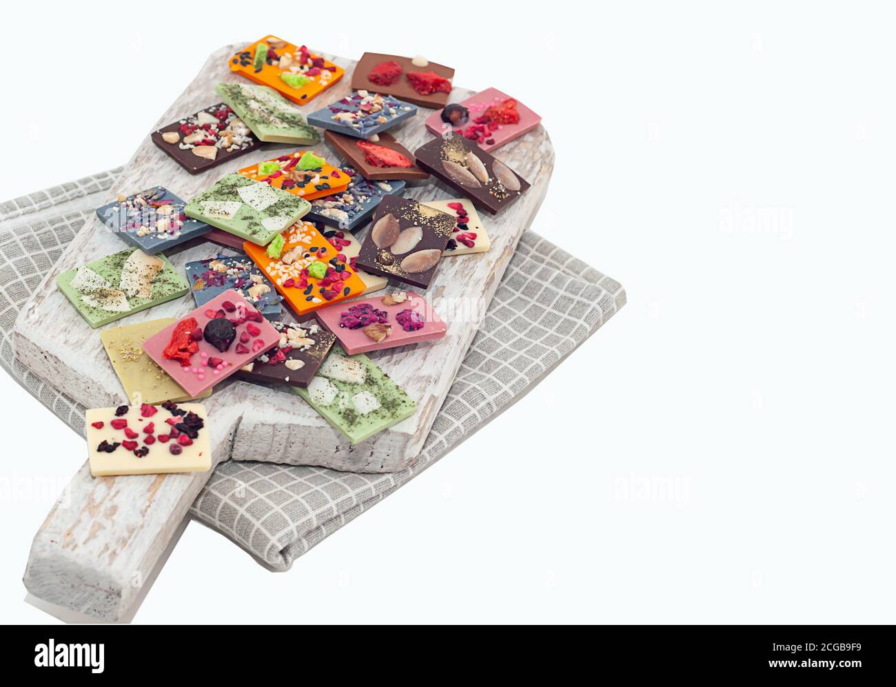 Natürliche belgische Schokolade mit verschiedenen Geschmacksrichtungen, aus Bio-Produkten, Matcha-Tee, grün, blau, Kokosnuss, bestreut mit Fruchtchips, Nüsse, Samen. Stockfoto