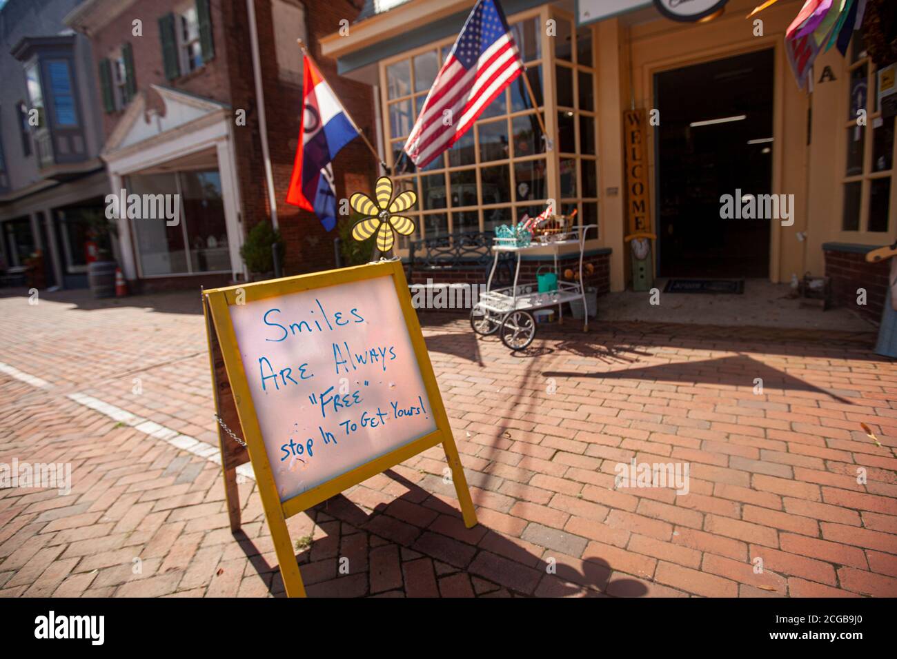 Eine frei stehende weiße Tafel, die außerhalb eines Vintage-Shops in Chestertown, Maryland, platziert wurde, hat ein handgeschriebenes Schild darauf, das sagt: "Meilen sind immer frei Stockfoto