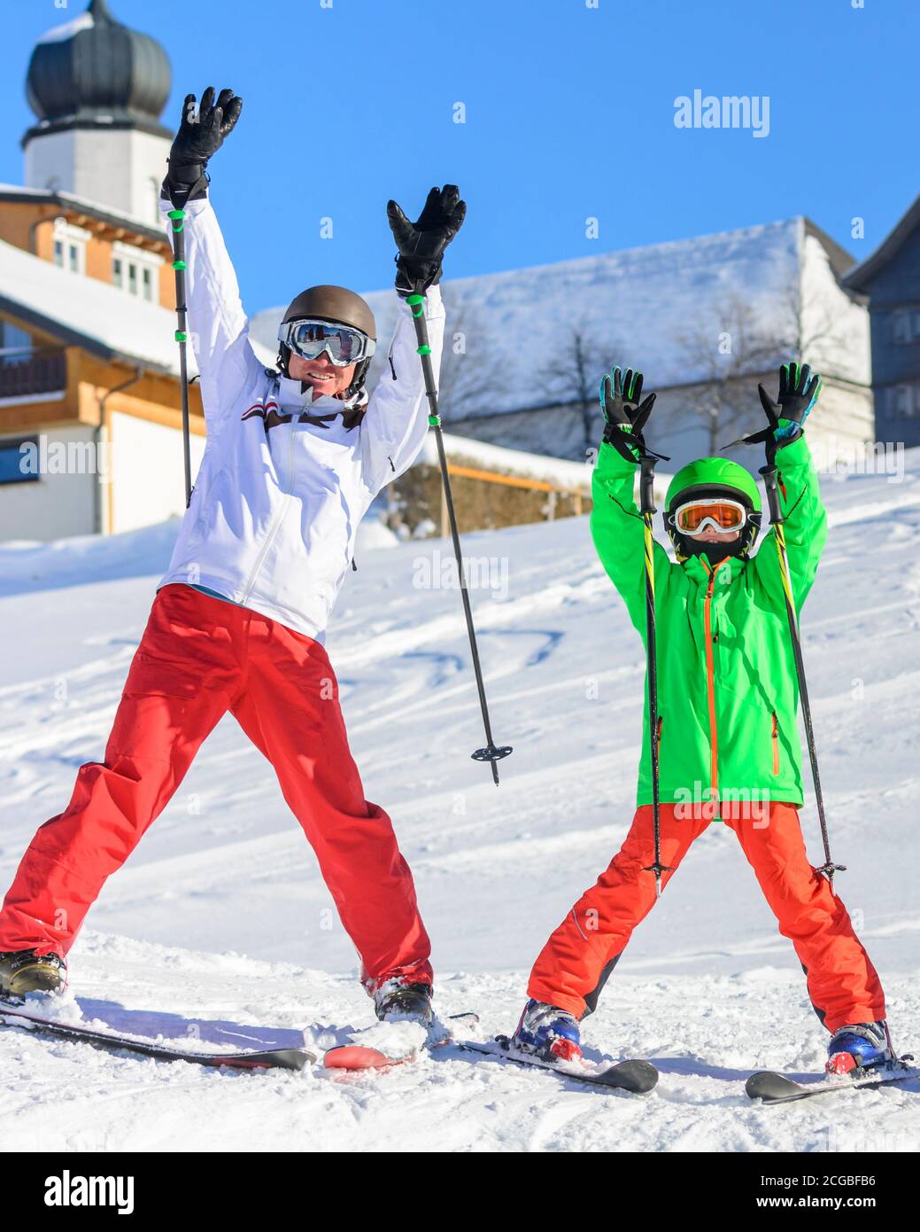 Lernen Sie mit Ihren Eltern auf einer gut präparierten Piste Ski zu fahren - und jeder hat viel Spaß. Stockfoto