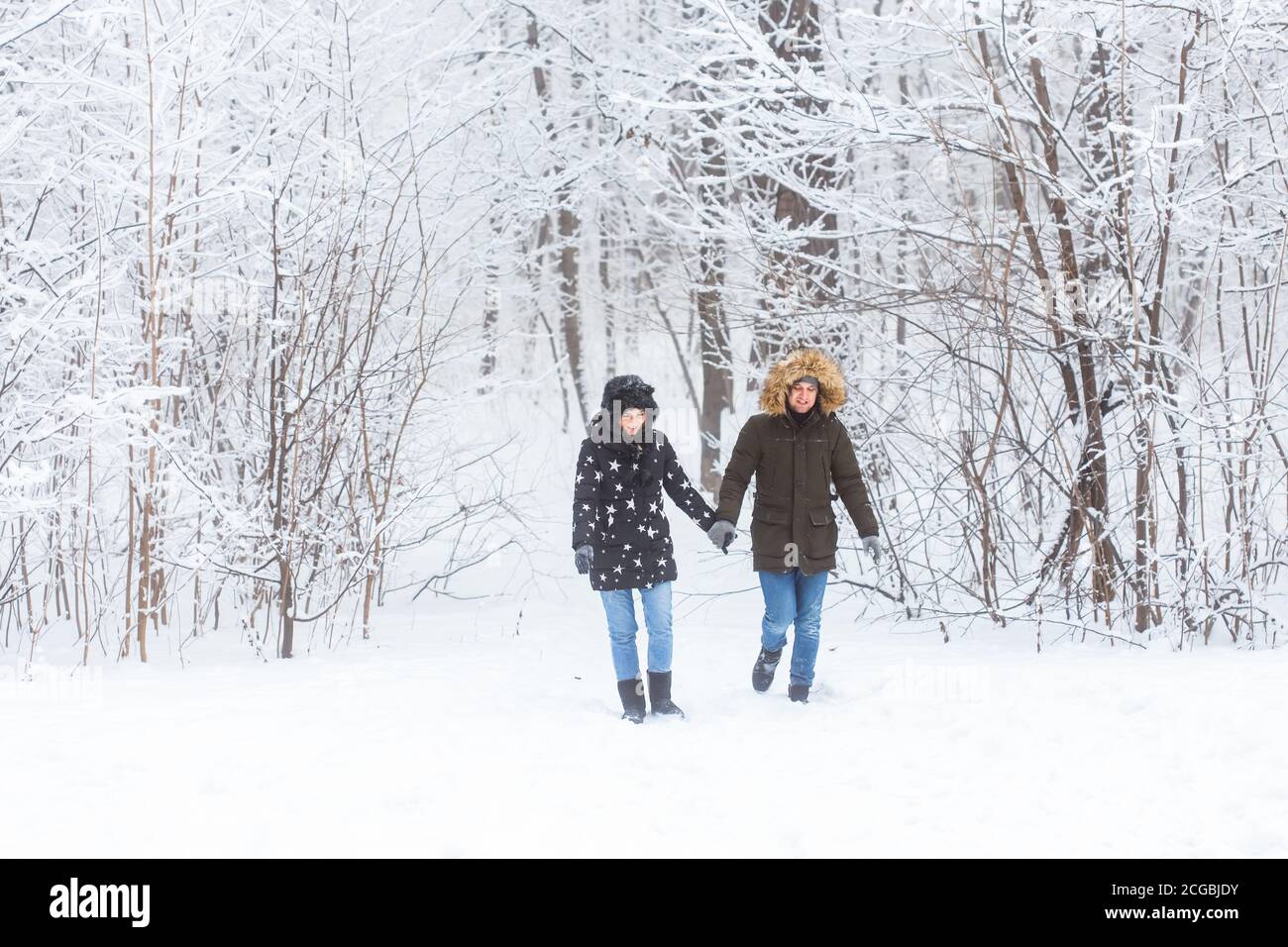 Junges Paar, das in einem verschneiten Park spazierengeht. Wintersaison. Stockfoto