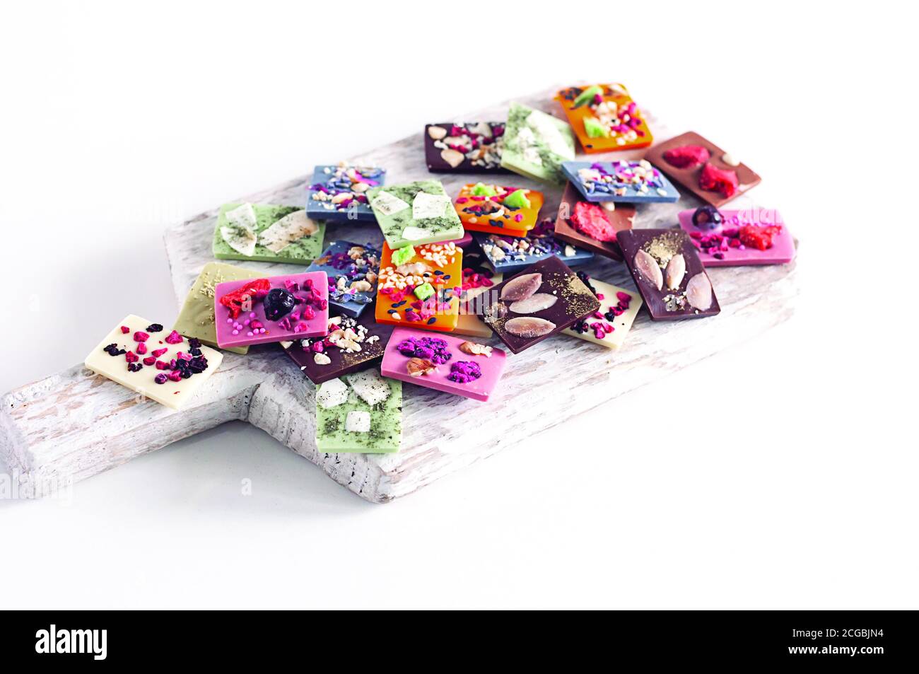 Natürliche belgische Schokolade mit verschiedenen Geschmacksrichtungen, aus Bio-Produkten, Matcha-Tee, grün, blau, Kokosnuss, bestreut mit Fruchtchips, Nüsse, Samen. Stockfoto
