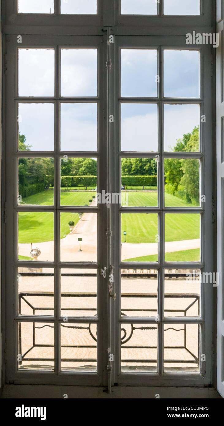 Blick auf den regulären Park durch ein Fenster mit Bars. Sommer Stockfoto