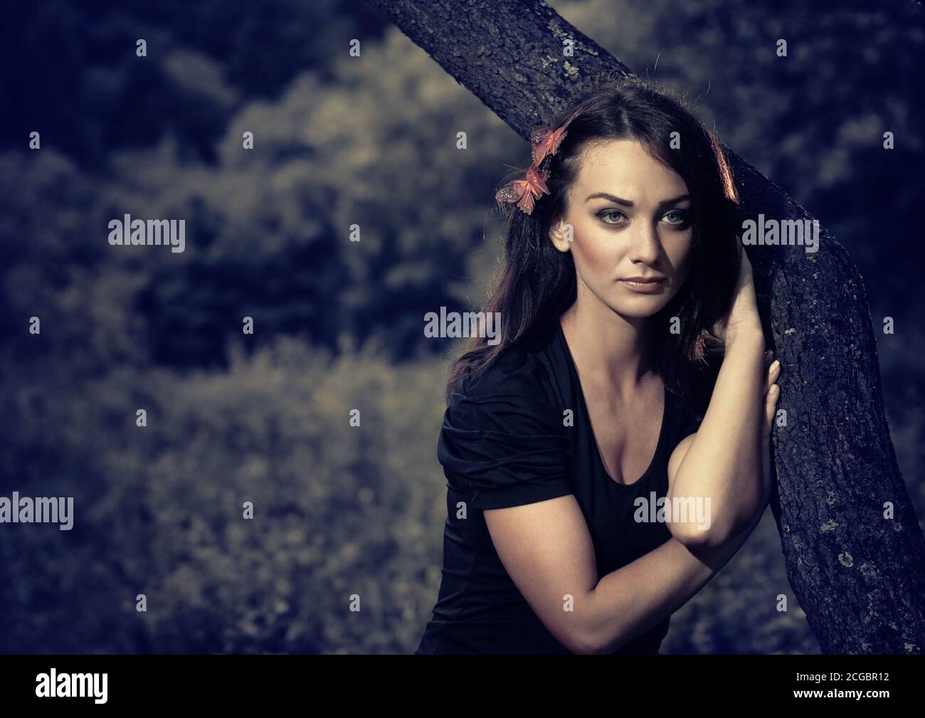 Junge Brunet in roten Kleid in alten Garten landschaftlich Stockfoto