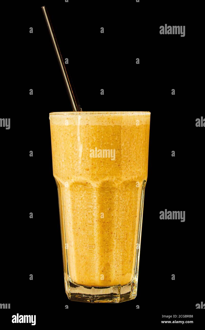 Orange Zitrusfrucht Smoothie in einem großen Glas auf schwarzem Hintergrund, isoliert. Stockfoto