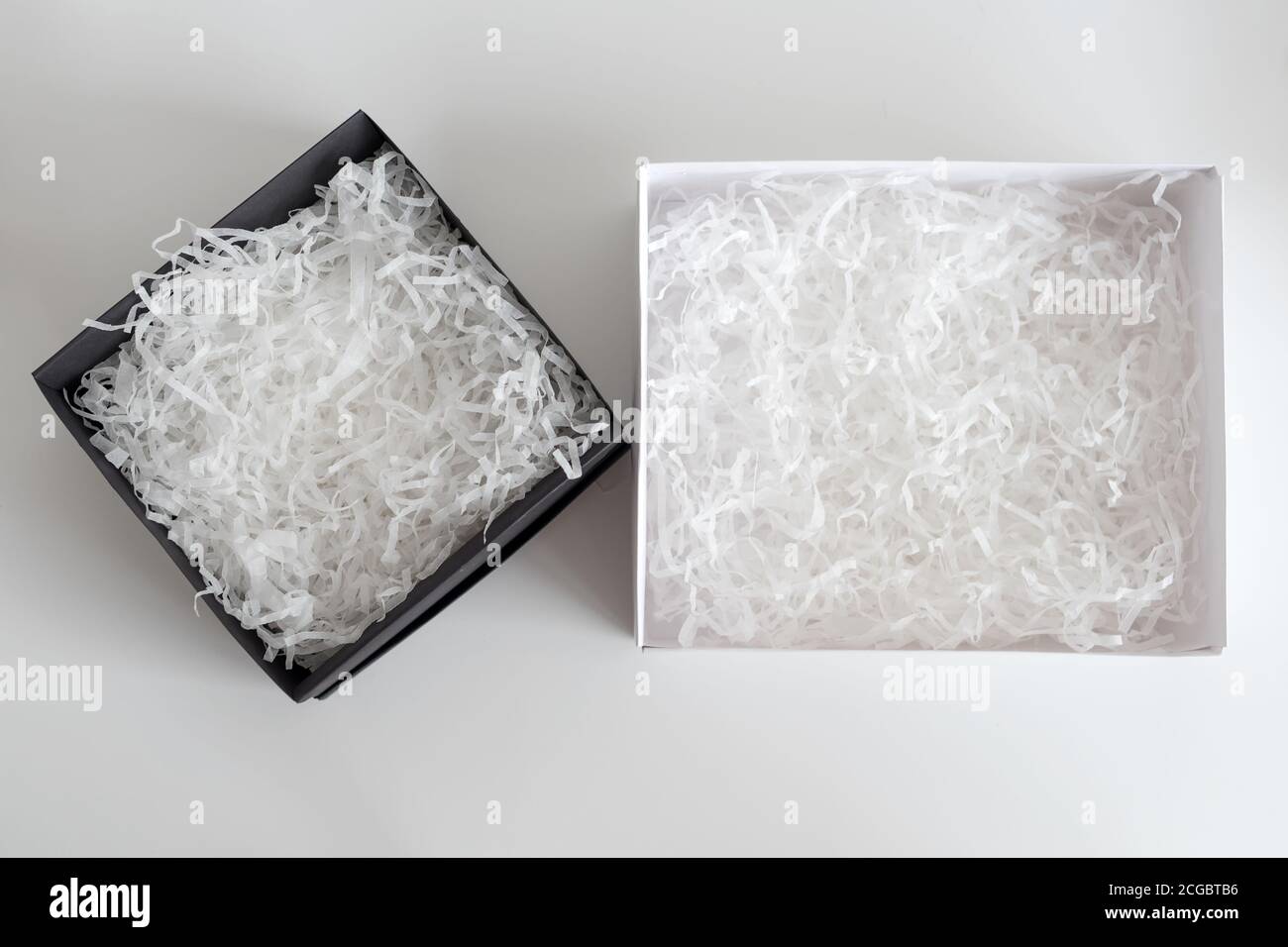 Geöffnete Geschenkschachteln mit dekorativem Stroh, Füllstoff, Späne. Papierbox für Ihre Produktplatzierung oder Montage. Geschenkverpackung. Draufsicht, flach liegend Stockfoto