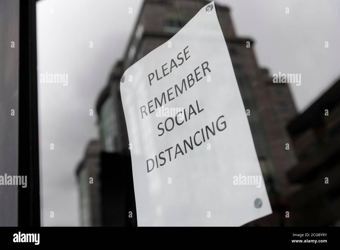Bitte denken Sie an ein soziales Distanzierungszeichen Stockfoto