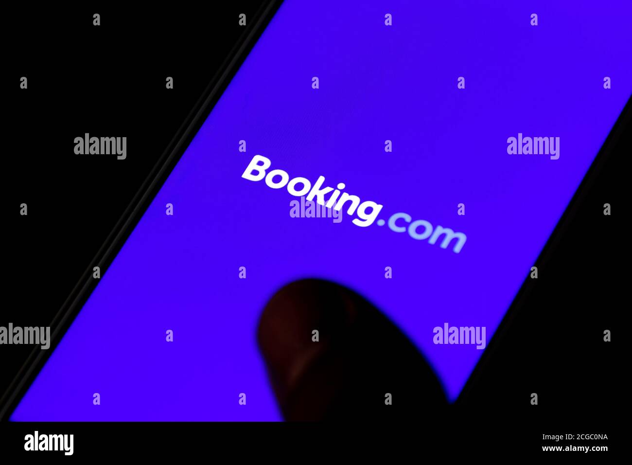 Booking.com Logo auf dem Smartphone angezeigt, Reise-und Hotelindustrie Krise durch Covid oder Coronavirus Pandemie, Umstrukturierung, mit Finger Stockfoto