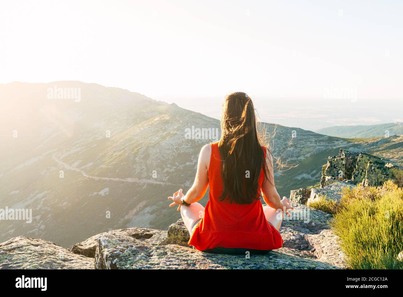 Frau übt Yoga und meditiert auf dem Berg. Stockfoto