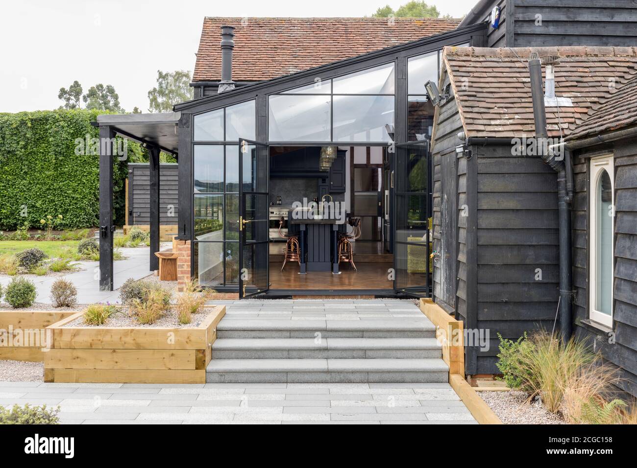 Außenansicht einer umgebauten Scheune/Mühle in Essex, Großbritannien, mit wunderschönen Stahlfenstern. Stockfoto