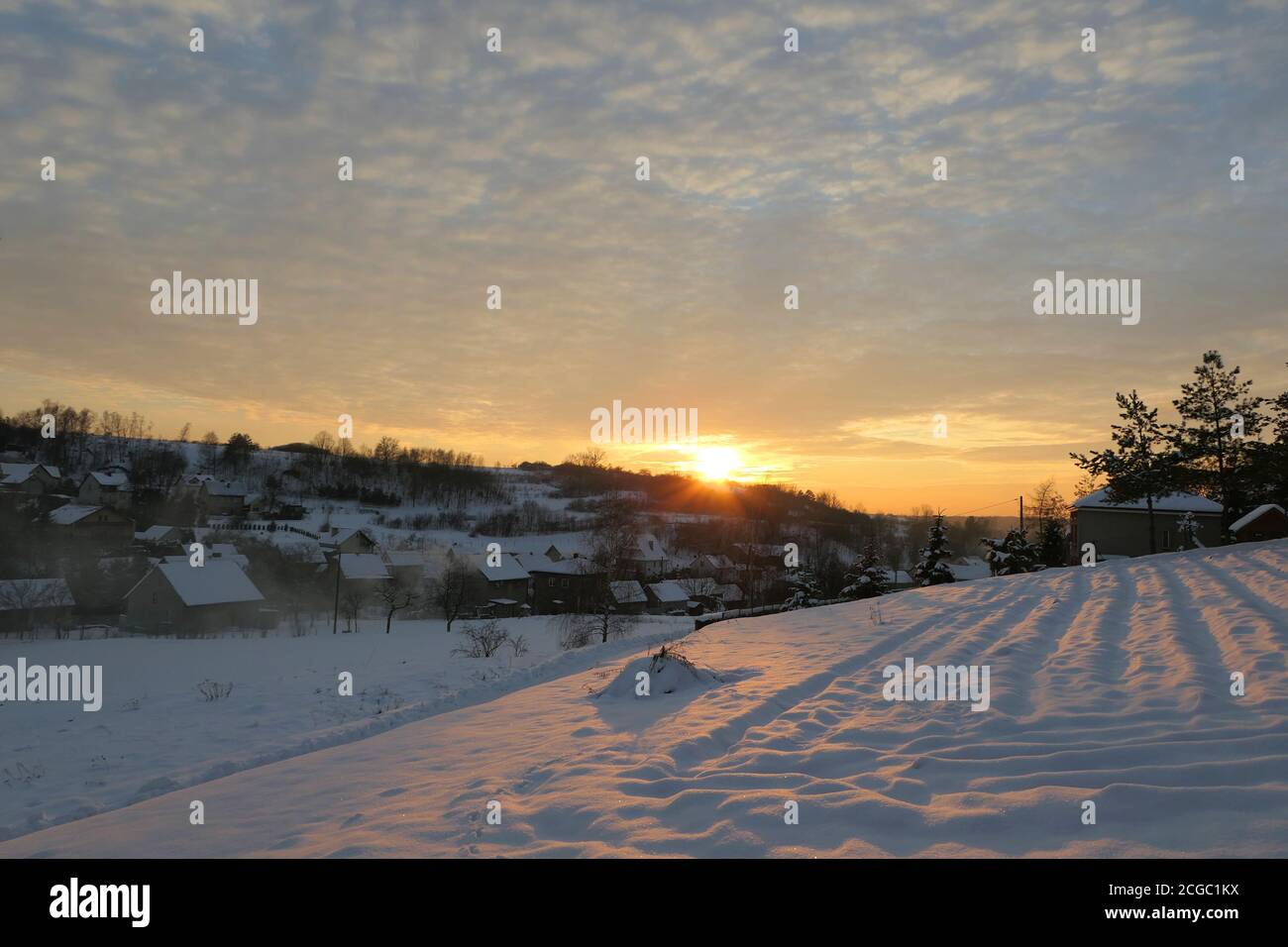 Sonnenuntergang Winter Schneelandschaft im Dorf in Polen. Stockfoto