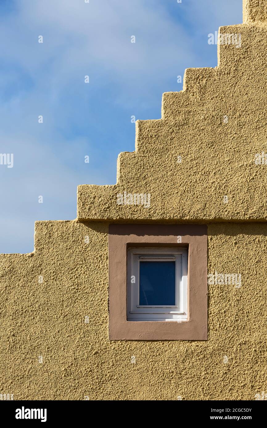 Fenster in gelber Stufengiebel gesetzt. Stockfoto