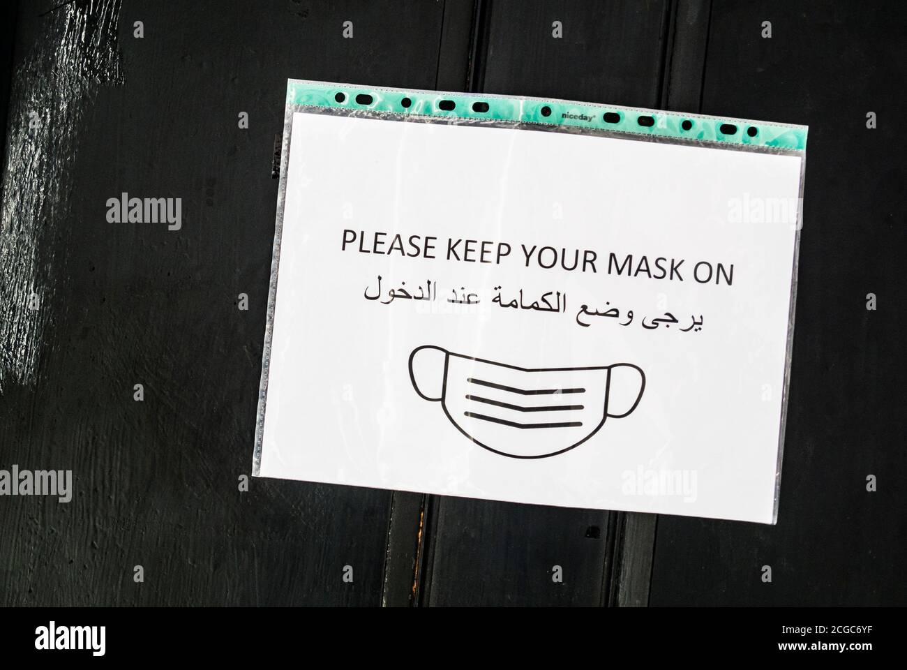 Gesichtsmaske Zeichen, Englisch und Arabisch Stockfoto