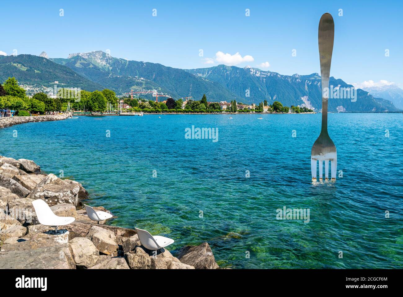 Leere Stühle auf Felsen am Ufer des Genfer Sees und Weltgrößte Gabel in  Vevey Schweiz Stockfotografie - Alamy