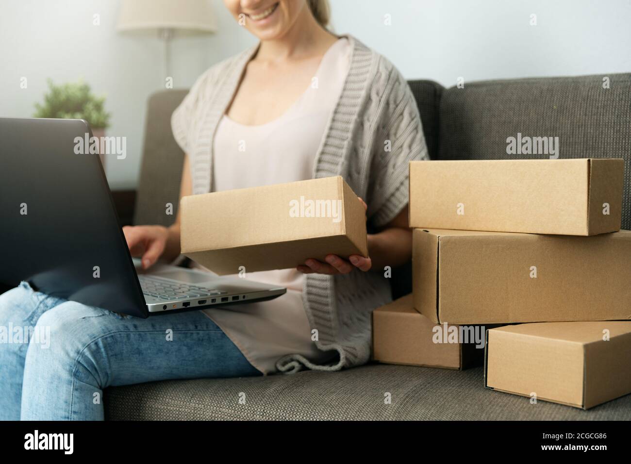 Verkauf von zu Hause. Kleinunternehmer Frau Überprüfung und Verpackung Briefkasten für den Versand aus Online-Shop Stockfoto