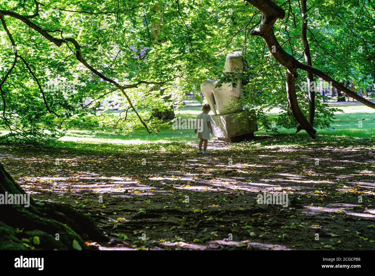 Danzig, Nordpolen - 13. August 2020: Ein kleines Mädchen, das allein im Schatten im Park steht und im Sommer die Natur erkundet Stockfoto