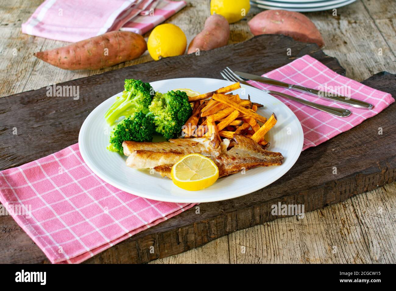 Fisch mit Süßkartoffeln und Brokkoli auf einem Teller Stockfoto