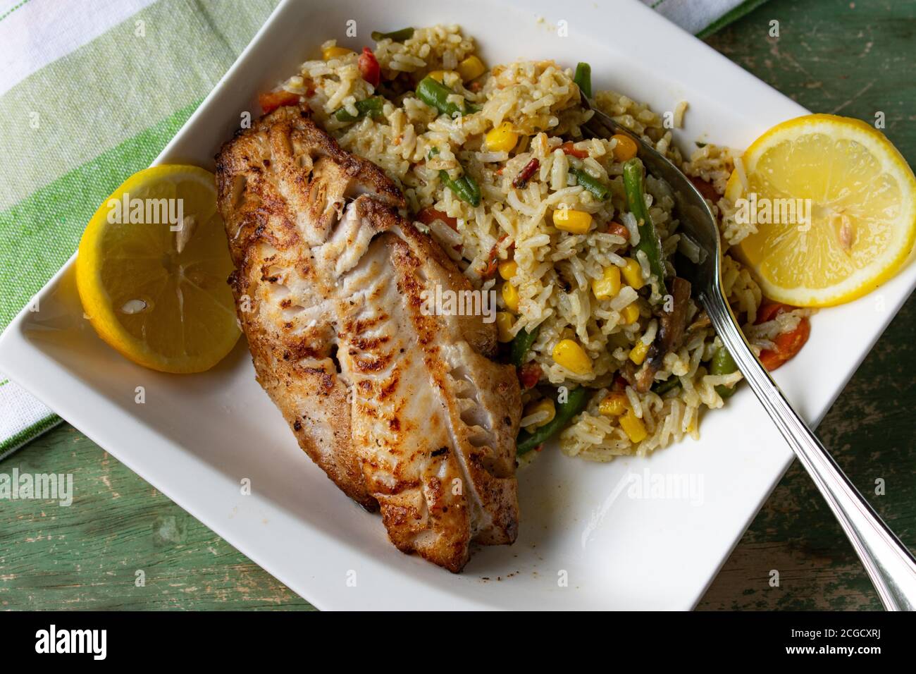 Natürliche Pfanne gebratenen Fisch mit braunem Reis und Gemüse Stockfoto