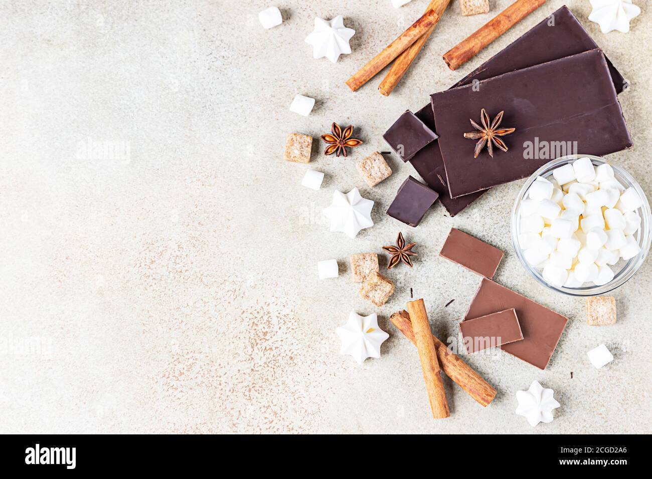 Dunkle und milchige Schokoriegel, Gewürze, brauner Zucker, Baiser und Marshmallow auf betontem Hintergrund. Sweet Food Foto Konzept. Draufsicht. Kopieren Stockfoto
