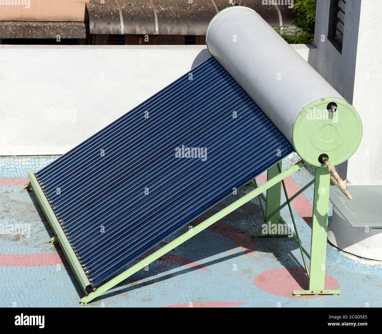 Solar-Warmwasserbereiter Einheit bestehend aus Rohrplatten und Wasser Lagereinheit auf der Terrasse eines Gebäudes installiert Stockfoto