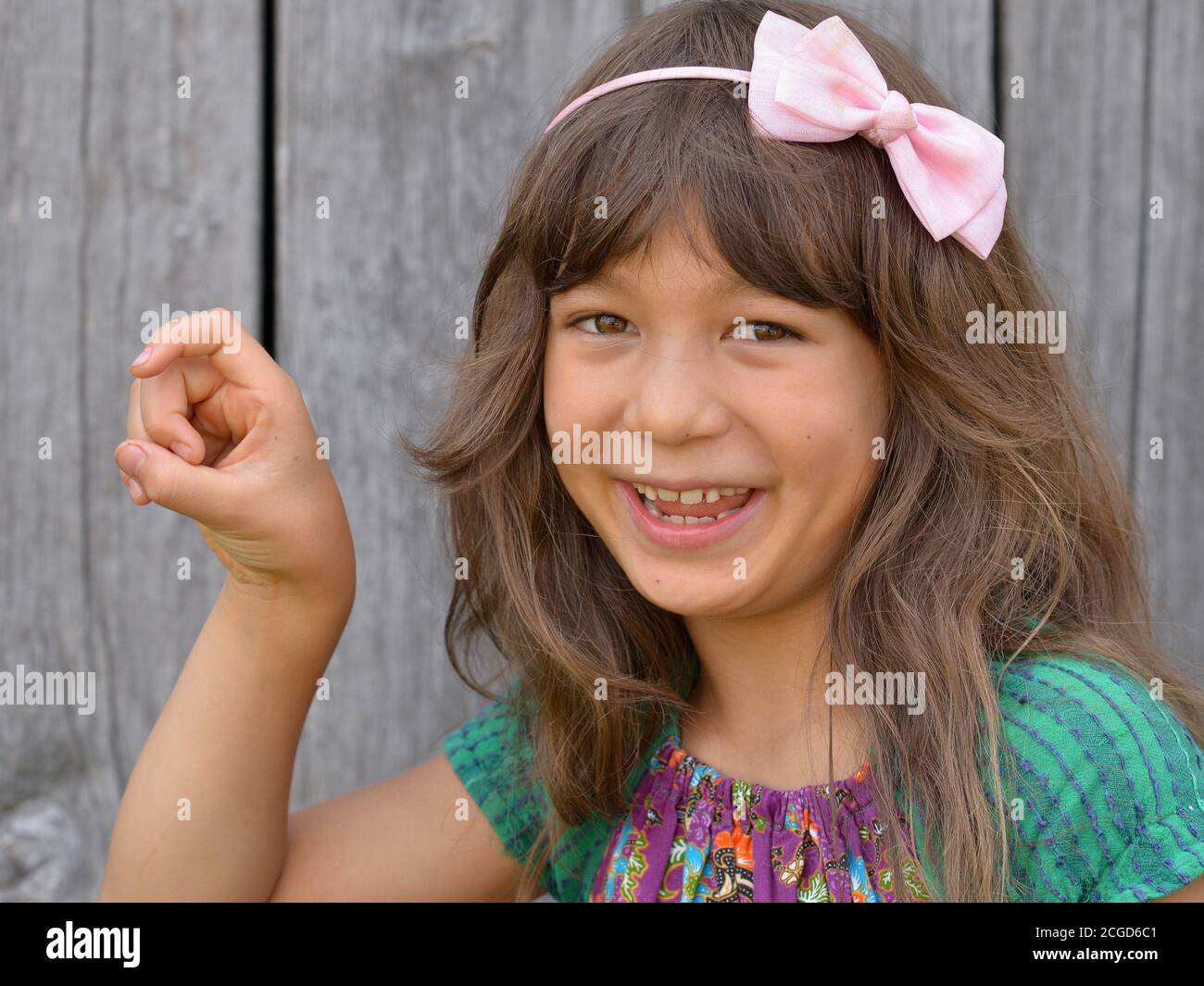 Niedliches gemischtes Mädchen (Ostasiatisch / Kaukasisch) zeigt mit der rechten Hand das chinesische Handzeichen für die Nummer 9 (Fotoserie: Bild-Nr. 9 von 10). Stockfoto