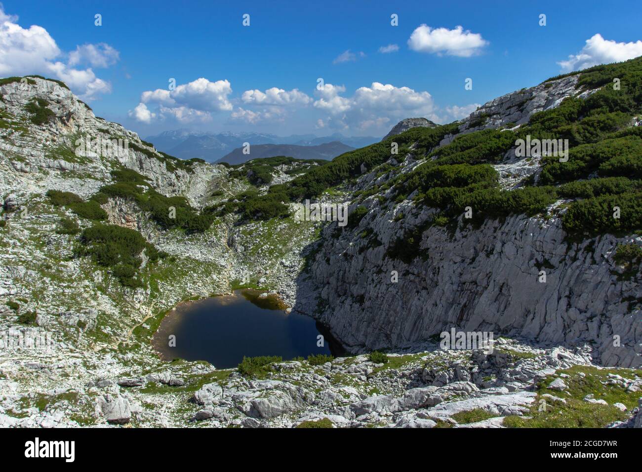 Blick auf felsige Berglandschaft und kleine dunkelgrüne See.Alpine Panorama-Landschaft.Sommerurlaub Reise Hintergrund.Entdecken Sie die Schönheit von Österreich. Stockfoto