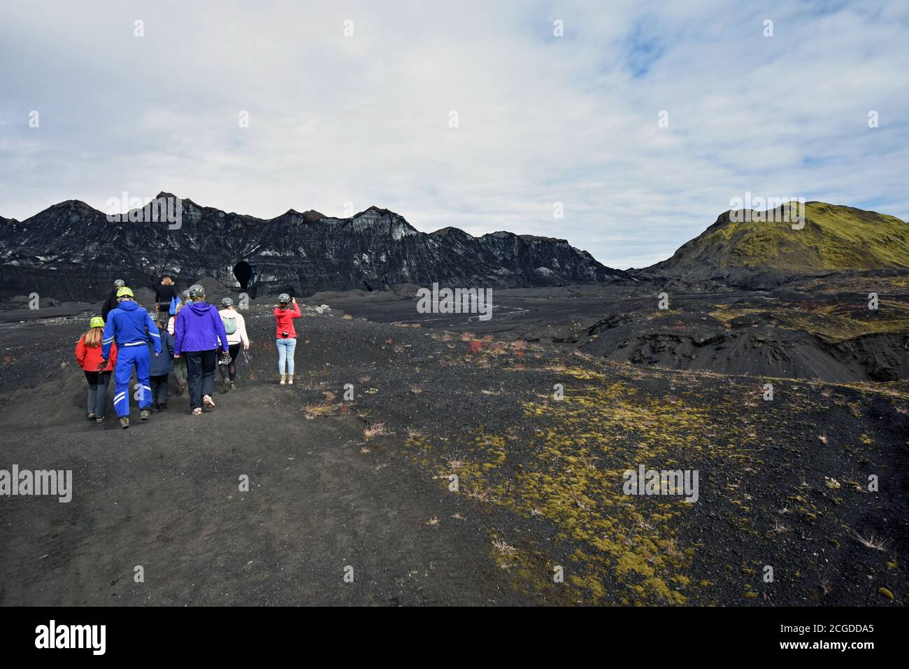 Eine Gruppenwanderung über die vulkanische Sandebene des Kotlujokull Glacier, Teil von Myrdalsjokull. Schwarzer Sand kontrastiert mit grünem Moos. Island Stockfoto
