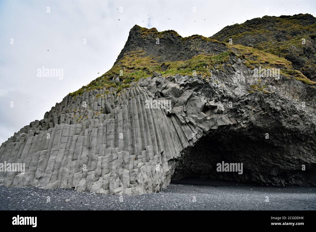 Die Reynisfjara Säulen auf Gardar Klippe. Halsanefsellir Sea Cave kann von den Basaltsäulen am Reynisfjara schwarzen Sandstrand, Süd Island gesehen werden. Stockfoto