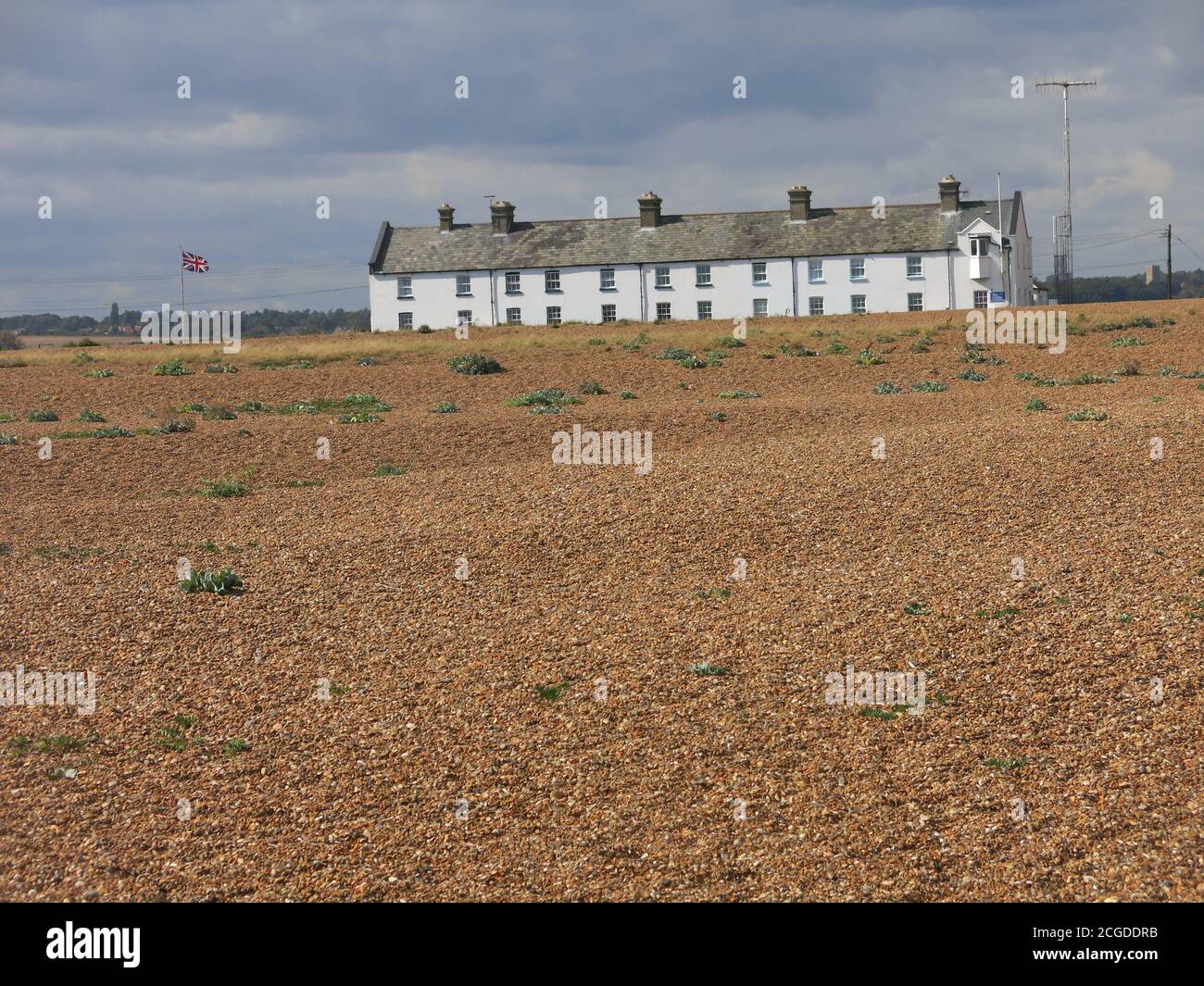 Eine Reihe von ehemaligen Küstenschutzhütten an der Shingle Street, einem isolierten Weiler an den düsteren Schindelbänken von Suffolk. Stockfoto