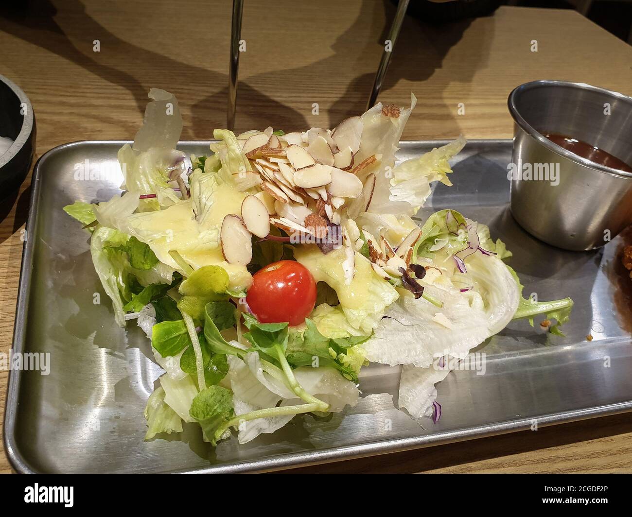 Salat aus verschiedenen Zutaten wie Salat, Kirschtomate und Mandelscheiben. Normalerweise serviert mit Tonkatsu, japanischem frittiertem Schweineschnitzel. Stockfoto