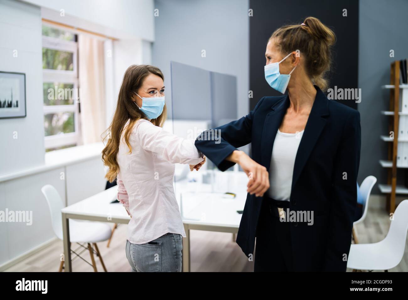 Mitarbeiter, Die Elbow Bump Machen, Um Grippe Zu Vermeiden Und Covid Zu Stoppen Verteilen Stockfoto