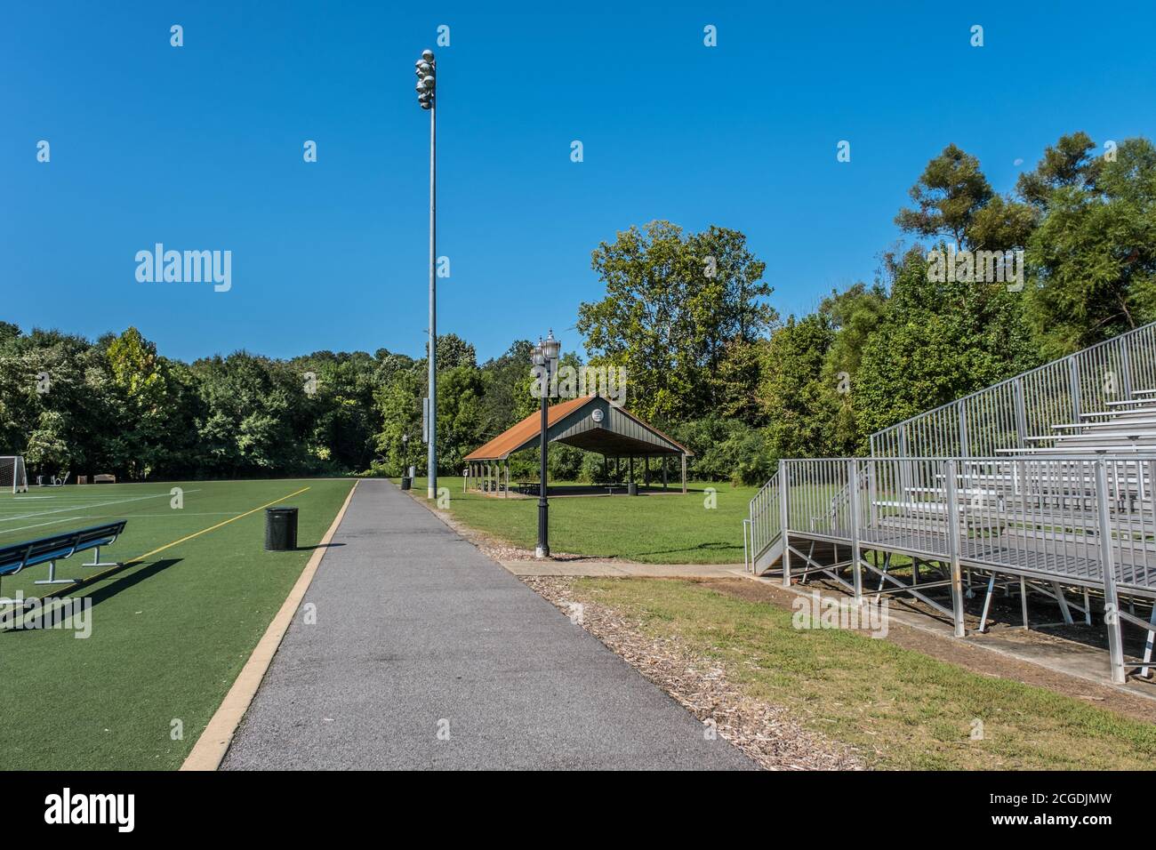 Ein gepflasterter Weg für alle Arten von Aktivitäten, die geht Rund um die Fußball- und Fußballfelder mit Bleichständen und Ein Picknickpavillon und eine Freiluftbeleuchtung Stockfoto